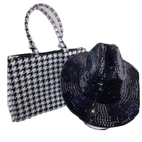 Black and white houndstooth patterned handbag and black fedora hat on a white background