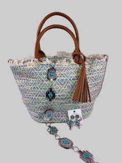 Handbag with decorative tassel and patterned strap on a white surface