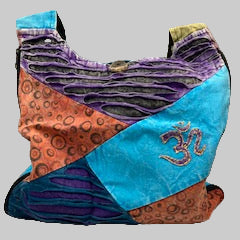 Colorful fabric bag with patterns and a symbol on a gray background